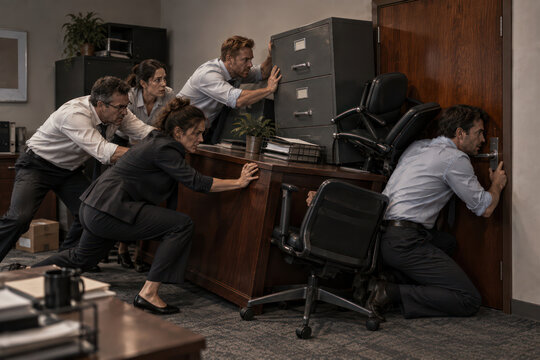 Coworkers Barricading Office Door with Furniture During Lockdown Emergency