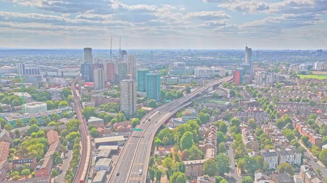 A40 Westway elevated dual carriageway and parallel railway cross dense residential districts beneath high-rise towers, Notting Hill area, Greater London, England, United Kingdom, drone slide