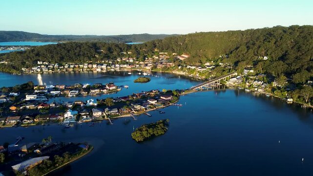Drone aerial landscape of residential housing and rural town homes along the waterfront at St Huberts Island and Daleys Point connected by a bridge across Brisbane Water on the Central Coast Australia