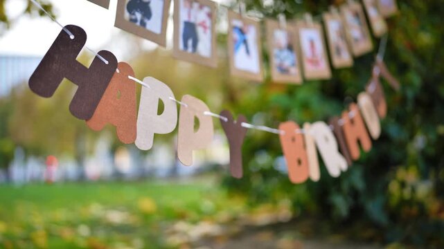 Celebrating birthday in an autumn park with personalized photo garland