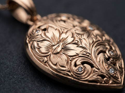 Ornate rose gold locket with floral engraving and diamonds