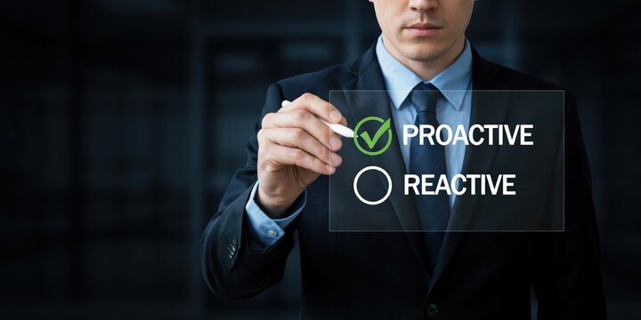 Businessman in a dark suit selecting proactive over reactive on a digital interface
