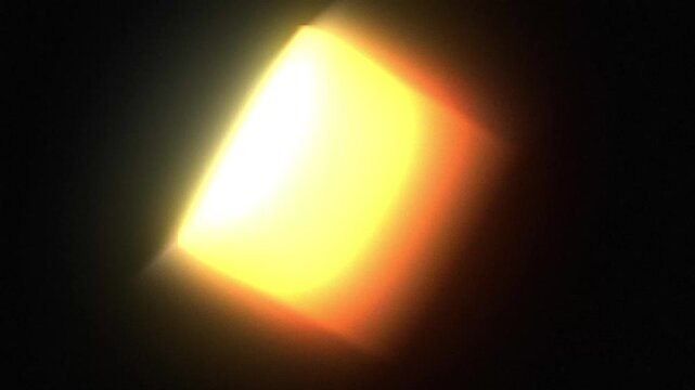 Bright yellow light flares glowing in the darkness for an abstract motion background effect