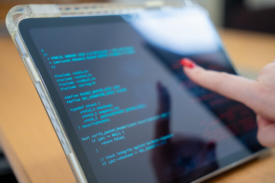 Programmer or IT pointing to code cybersecurity on laptop at home office for concept verifying code algorithm. Employees woman write code, typing on computer for software development. Remote work.
