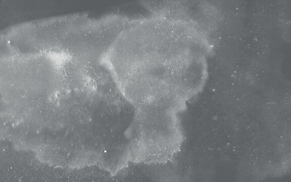 Abstract grunge texture with light dust and scratches on a dark grey background, vintage film grain effect overlay for photography and design