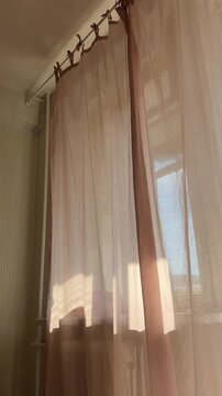 Home interior background with transparent window curtains in sunny day with sun glare. Domestic lifestyle.