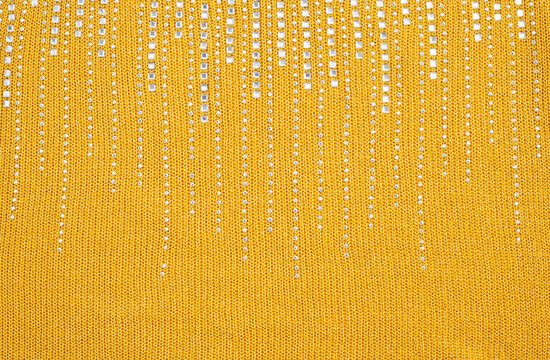 Yellow knitted fabric with silver sequin strands texture