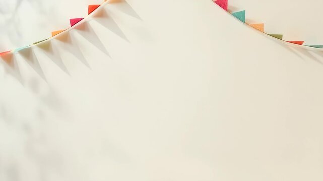 Colorful Triangular Bunting Garland Party Decoration on Cream Wall with Soft Shadows