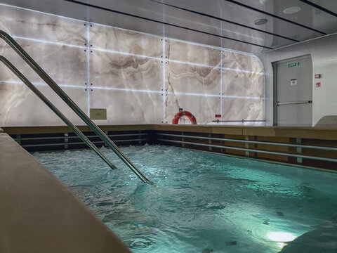 Indoor swimmingpool with hot tub whirlpool inside thermal suite in spa or wellness area onboard luxury modern cruiseship or cruise ship liner for beauty and balance