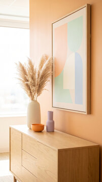 Warm sideboard vignette with pampas grass, geometric framed art and ceramic vases on peach wall