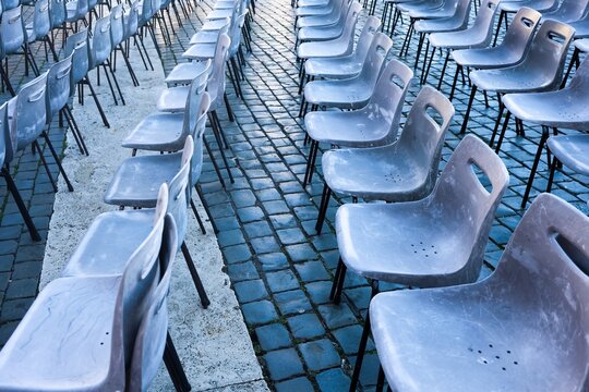Empty chairs rows on Rome cobblestones awaiting audience