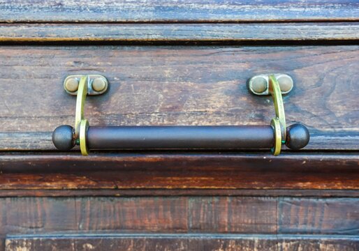 Ornate brass handle adorning old wooden door in Rome