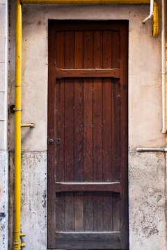 Old wooden door on a textured building wall in Rome