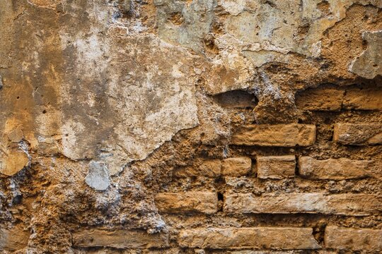 Ancient brick wall with decaying plaster texture in Rome