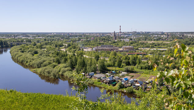 A panorama of provincial city in northern Russia showing winding river, private houses, and industrial part of the city.