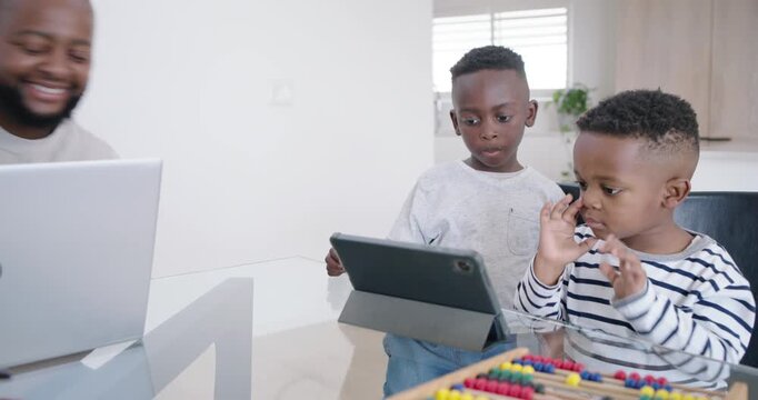 African American father leaning, pointing at tablet guiding two boys tapping near abacus to learn