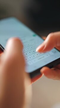Female hands typing text on smartphone close-up.