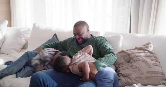 African American father with 2 kids starting tickling holding and lifting on white sofa for bonding