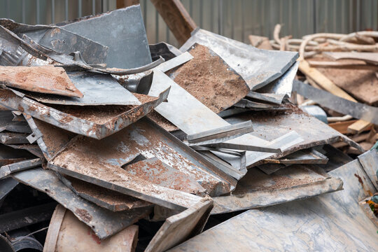 Heap of rusted metal sheets and scrap panels stacked outdoors in an industrial yard, showing corrosion, texture and disorder. Suitable for themes like recycling, waste management and construction