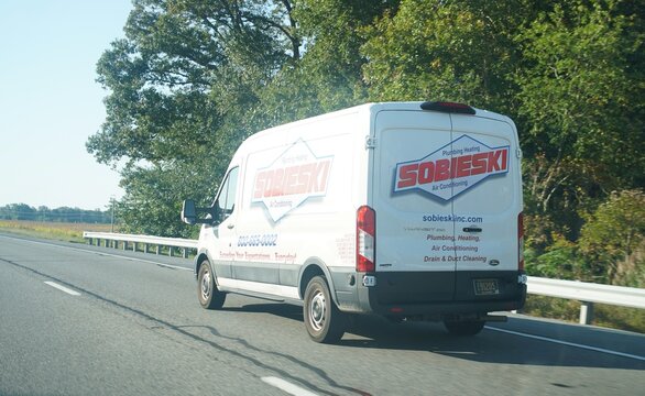 Dover, Delaware, U.S.A - Oct 14, 2026 - A white Sobieski plumbing, heating, and air conditioning service van driving along Route 1