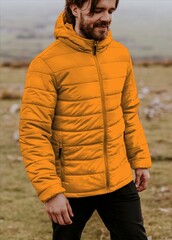 Man wearing orange puffer jacket outdoors in countryside © Rawpixel.com