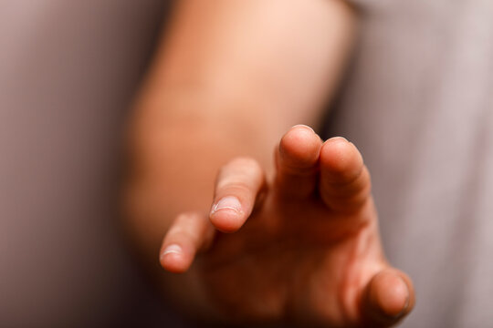 A close-up of a person's hand extending forward, implying touch, innovation, or help.