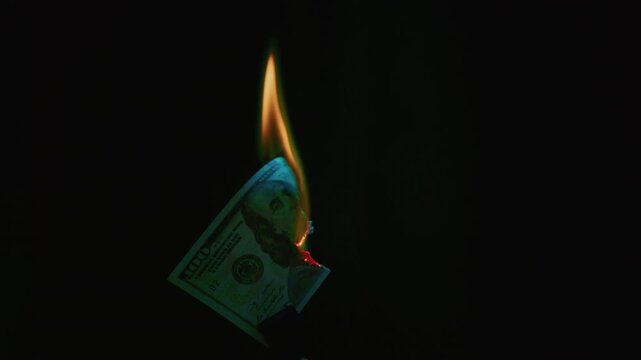 Banknote of American dollar is on fire, burning with a bright flame Unstable economy. Depreciation of dollar, detailed paper. Money loss, financial crisis, inflation, wealth and economic instability