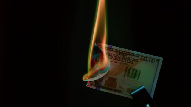 Burning dollar paper bill. Hundred dollars goes up in flames. USD , financial loss and waste. Collapse of the economy, democracy and capitalism. Inflation and depreciation of the US currency.