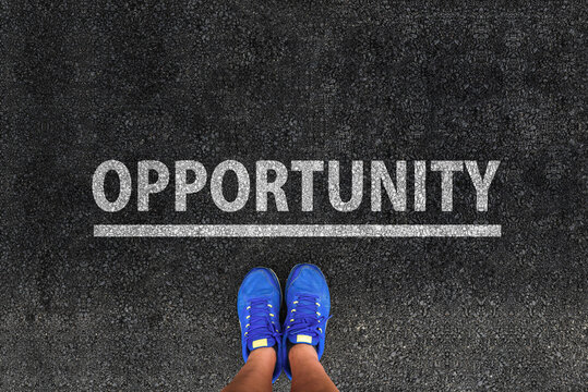 Person standing on asphalt road next to Opportunity word text painted on pavement, concept of decision, future choice and career growth.