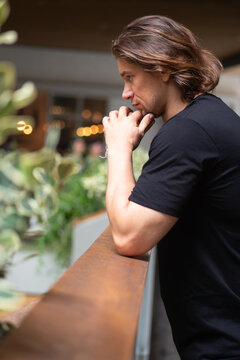 30s caucasian man in casual clothing thinking alone in an indoor garden