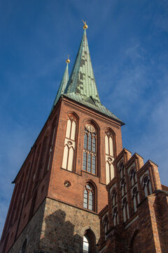 Low-angle view of the historic red-brick Nikolaikirche tower in Berlin's Nikolai Quarter