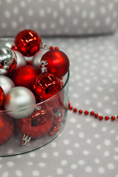 Close-up of Red and silver metallic Christmas baubles in a glass bowl ib a polka dot blanket