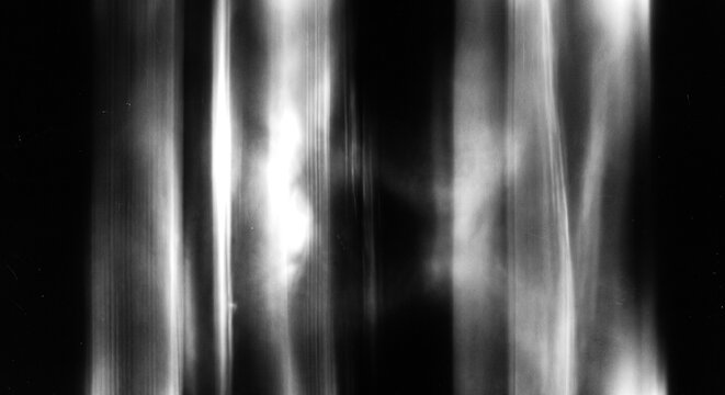 Abstract monochrome background with bright vertical light streaks and subtle film grain texture