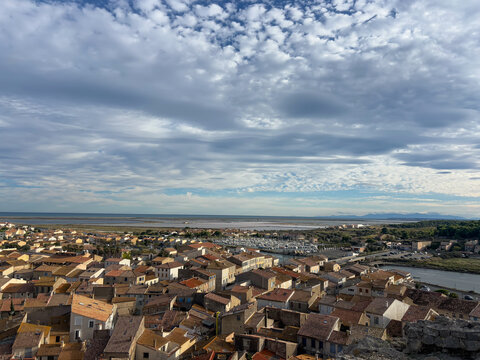 Picturesque elevated view of Gruissan, France, from the medieval Ch&acirc;teau de Gruissan, also known for the Tour Barberousse, with terracotta rooftops glowing in the warm light of the setting sun