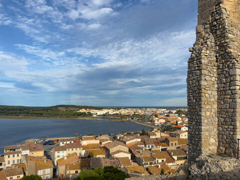 Picturesque elevated view of Gruissan, France, from the medieval Ch&acirc;teau de Gruissan, also known for the Tour Barberousse, with terracotta rooftops glowing in the warm light of the setting sun