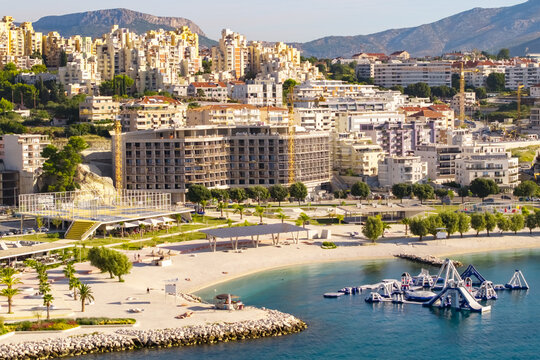 Aerial panorama of Žnjan beach in Split with a landscaped waterfront, recreational facilities, floating water park, turquoise Adriatic waters and a dense urban skyline