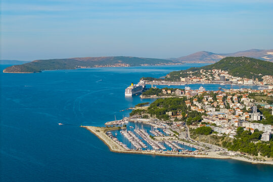 Wide aerial panorama of Split showing the historic coastal city, marinas, beaches and residential neighborhoods surrounding the green Marjan peninsula