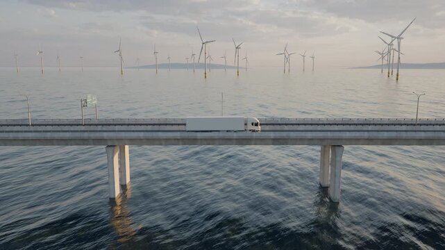 A fixed wide side view shows a white semi truck driving left to right across a long bridge over water, with offshore wind turbines stretching across the background.