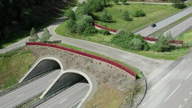 Wide aerial view of ecoduct green bridge over motorway in Swedish landscape