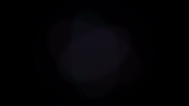 Soft purple bokeh light spots flickering on dark background