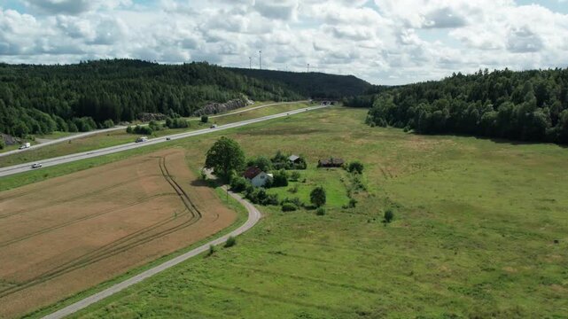 Aerial view of E45 motorway past farm and forest near Lilla Edet, Sweden