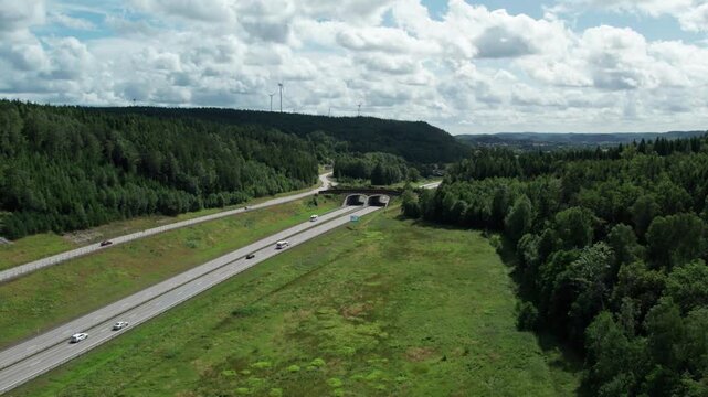 Drone flying towards ecoduct green bridge over E45 motorway, Lilla Edet, Sweden