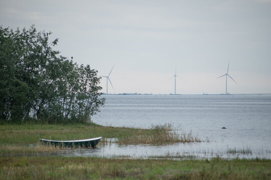 boat on the Gulf of Bothnia. On he background, there are wind generators from Oulu seashore.