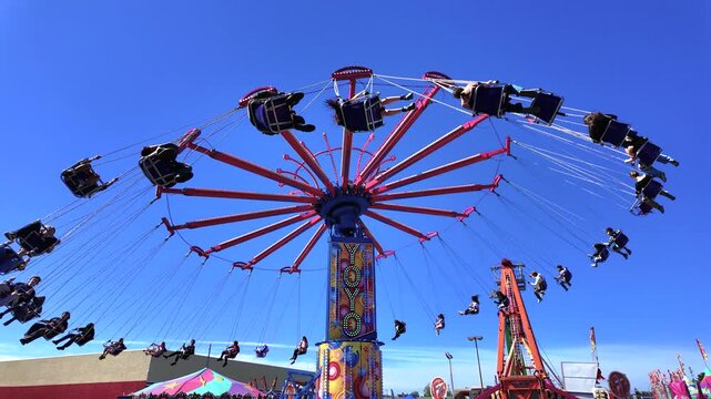 Victoria, British Columbia, Canada - October 15, 2026: People riding the Yo-Yo wave swinger chair swing ride at a carnival fair