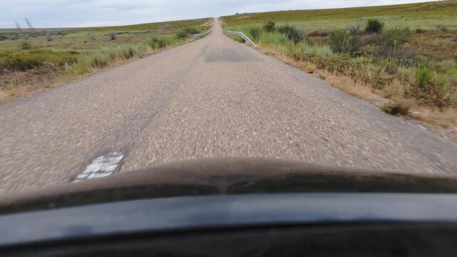 Driving Along a Lonely Road Through Arid Open Steppe