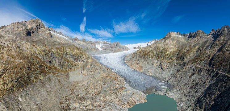 Panoramic aerial view of Rhone Glacier melting into glacial lake and rocky valley, Swiss Alps, Switzerland
