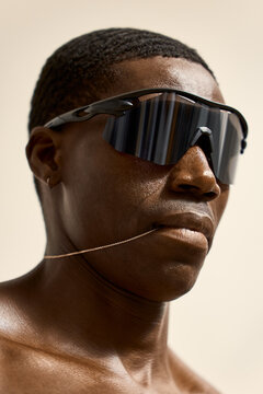 Person wearing sunglasses and a necklace poses for camera