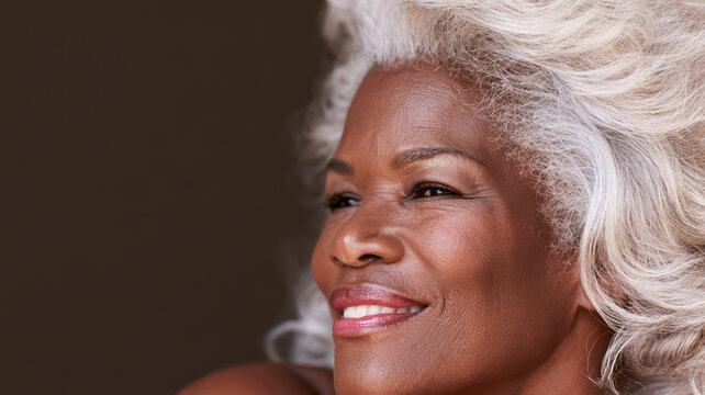 Elderly Black woman with silver hair, dignified portrait, warm smile and natural beauty in soft light