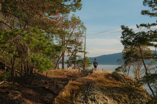 Man with backpack hiking in British Columbia at sunset in summer