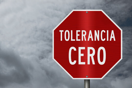 Red Zero Tolerance sign Tolerancia Cero in Spanish with stormy sky